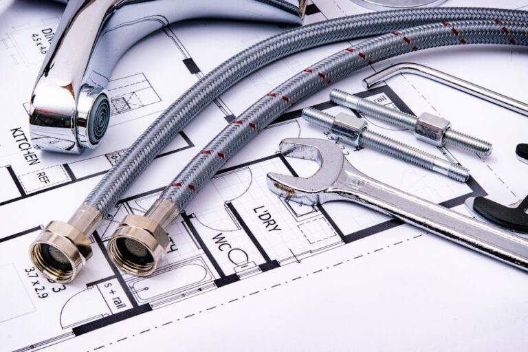 selfio - Close-up of plumbing tools and faucet on top of an architectural blueprint, perfect for har