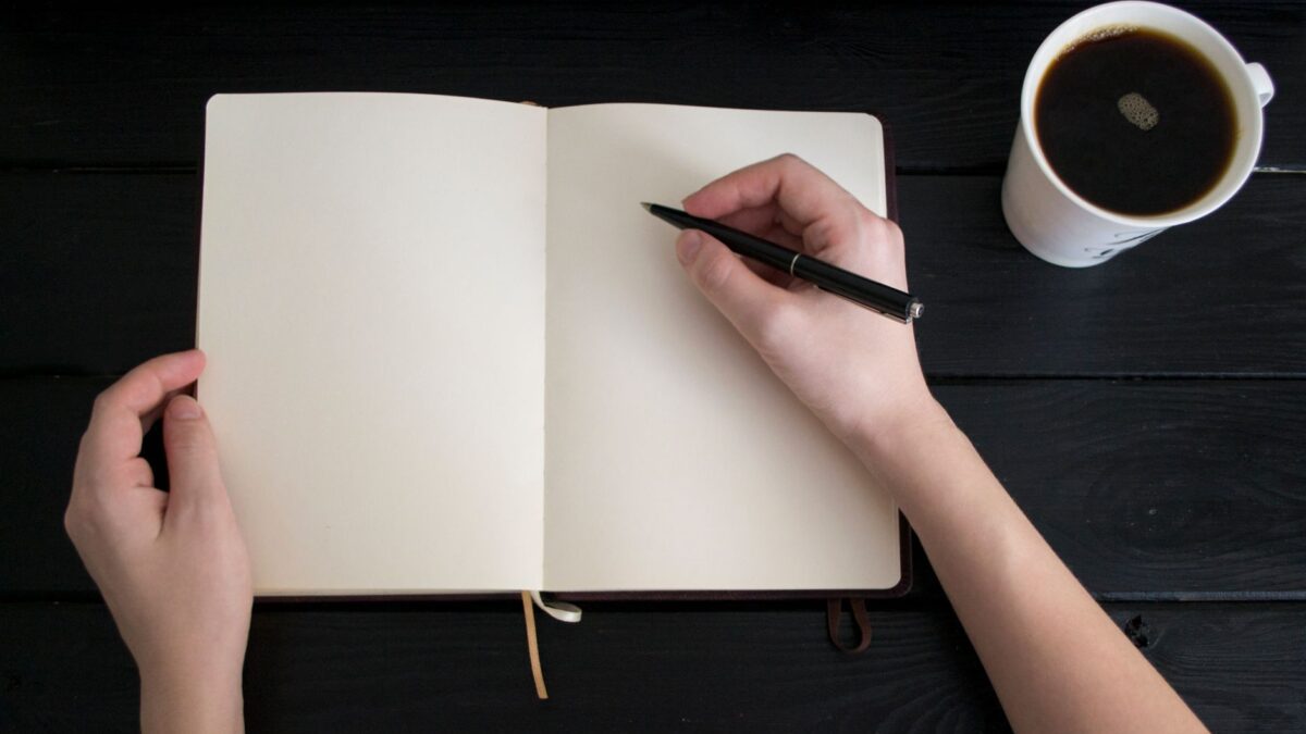 Empty notebook with a pen and coffee cup, perfect for writing inspiration concepts.